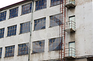 Old decaying factory exterior with rusty ladder