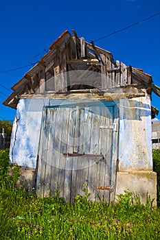 Old degraded house under blue sky