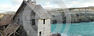 Old derelict wooden house overlooking the sea