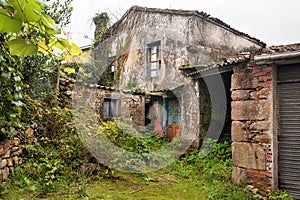 An old destroyed abandoned house in Spain, Europe. Broken windows, damaged walls and overgrown garden photo