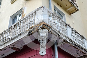 The old destroyed balcony at the corner of the house. Rusty and with the elements which have flown away from time.