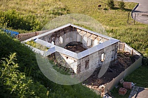 Old destroyed stone house on the yard with trees around. Poverty and misery, Summer