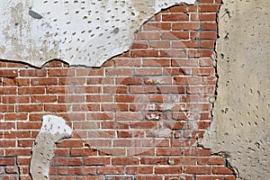 Old deteriorating clay brick wall texture showing faded and cracked paint