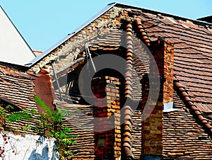 old deteriorating and collapsing house detail. broken and leaning brick chimney