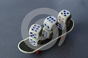 Old dice and finger skate on a gray background