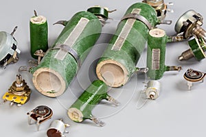 Old different fixed, variable and adjustable resistors on a gray surface