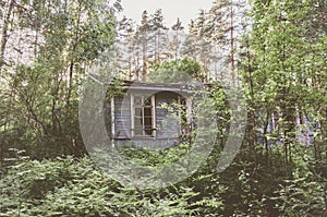 Old dilapidated one-story building in the forest