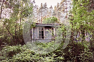 Old dilapidated one-story building in the forest
