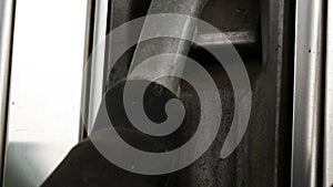 Old dilapidated rusty fuel nozzle at gas station hangs close up view