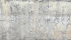 An old dirty battered concrete wall with cracks. The dilapidated wall of the building, tarnished by time