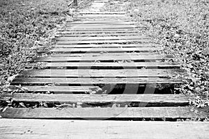 old and dirty broken wood bridge on walk way in black and white photography