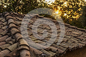Old dirty brown shingle house soft focus roof outdoor in evening sunset time with sun rays background, rural environment