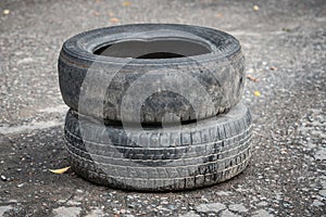 Old dirty car tires on cracked asphalt. Close-up
