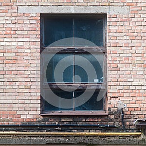 Old dirty cracked window in the stairwell