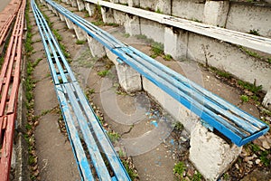Old dirty destroyed blue and red grandstands at
