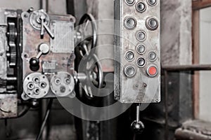 Old, dirty hanging vertical system and control panel with buttons for industrial equipment in the factory