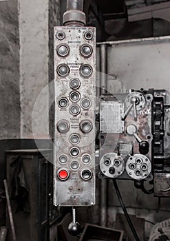 Old, dirty hanging vertical system and control panel with buttons for industrial equipment in the factory