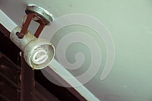 Old dirty light bulb hanging on ceiling