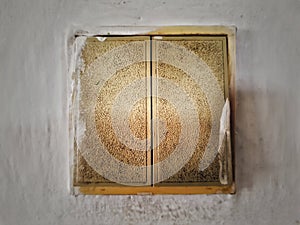 Old dirty light switch on old cracked wall