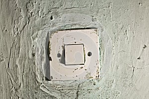 Old dirty light switch on old cracked wall