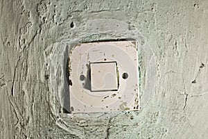 Old dirty light switch on old cracked wall