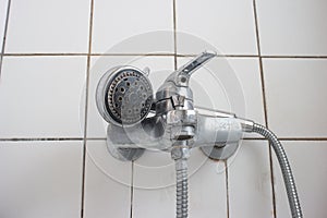 Old dirty limescale chalk covered shower head and bathtub faucet close up low angle view