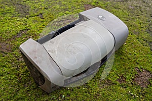 An old dirty printer with moss in the background.