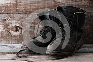 Old dirty shoes boots ankle boots on a wooden background