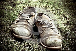 Old dirty shoes on grass