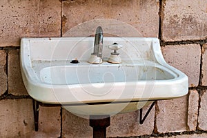 Old dirty sink against brick wall close view