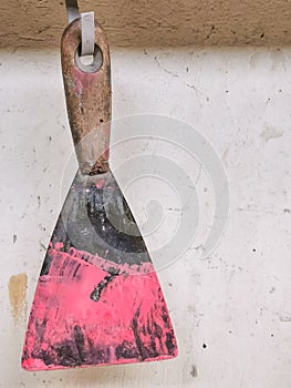 Old dirty spatula scraper image with paint hang on the wall. photo