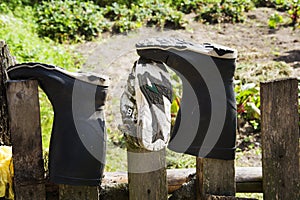 Old dirty torn shoes on a wooden fence