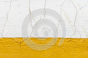 Old dirty wall with cracked yellow paint and plaster