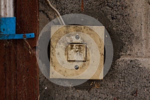 Old dirty white light switch on the wall