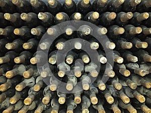Old dirty wine bottles stacked up in cellar