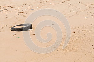 Old discarded tire laying on beach