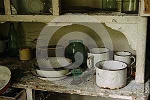 Old dishes in a closet in an abandoned house. Old kitchen. An empty uninhabited house.