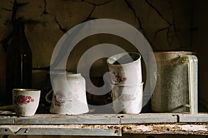 Old dishes in a closet in an abandoned house. Old kitchen. An empty uninhabited house.