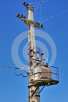 Old distribution transformer on concrete power pole