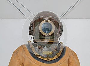 An old diving helmet with diving suit.