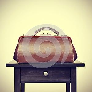 Old doctors bag on a table, with a retro filter effect