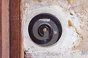 Old vintage door bell button on grunge wall