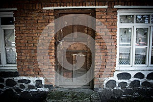 old door of brick building close up. The red brick wall and wooden door shot