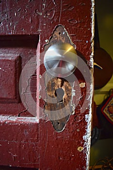 Old door detail with removed plate and replacement knob