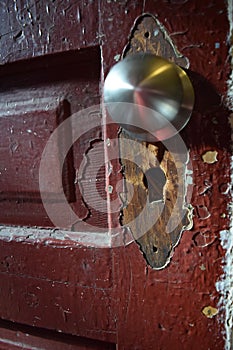 Old door detail with removed plate and replacement knob. Angled