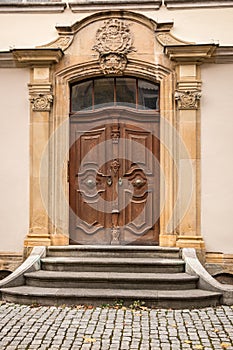 Old door of a historical building with coats of arms made of stone