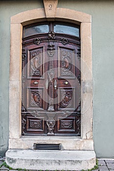 Old door of a historical building with stairway and house number
