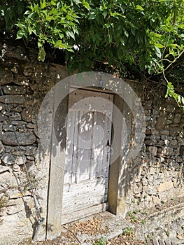 old door with its wrought iron in a stone wall