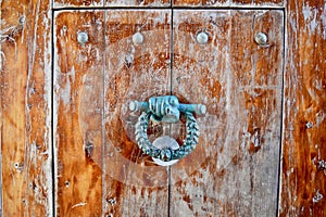 Old door knock against a weathered wood door