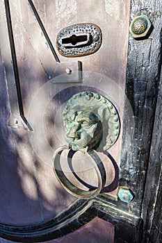 Old door knocker, bronze lion, old door at the entrance of Toplou monastery, Crete, Greece